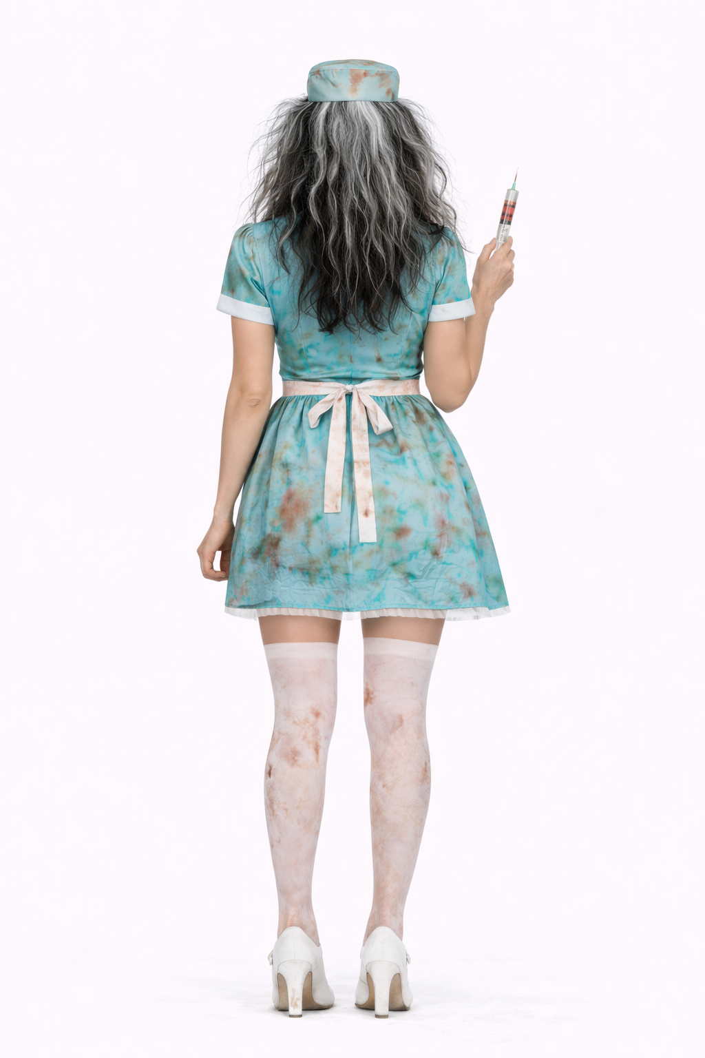Person wearing a teal dress with floral patterns, holding a syringe on a white background